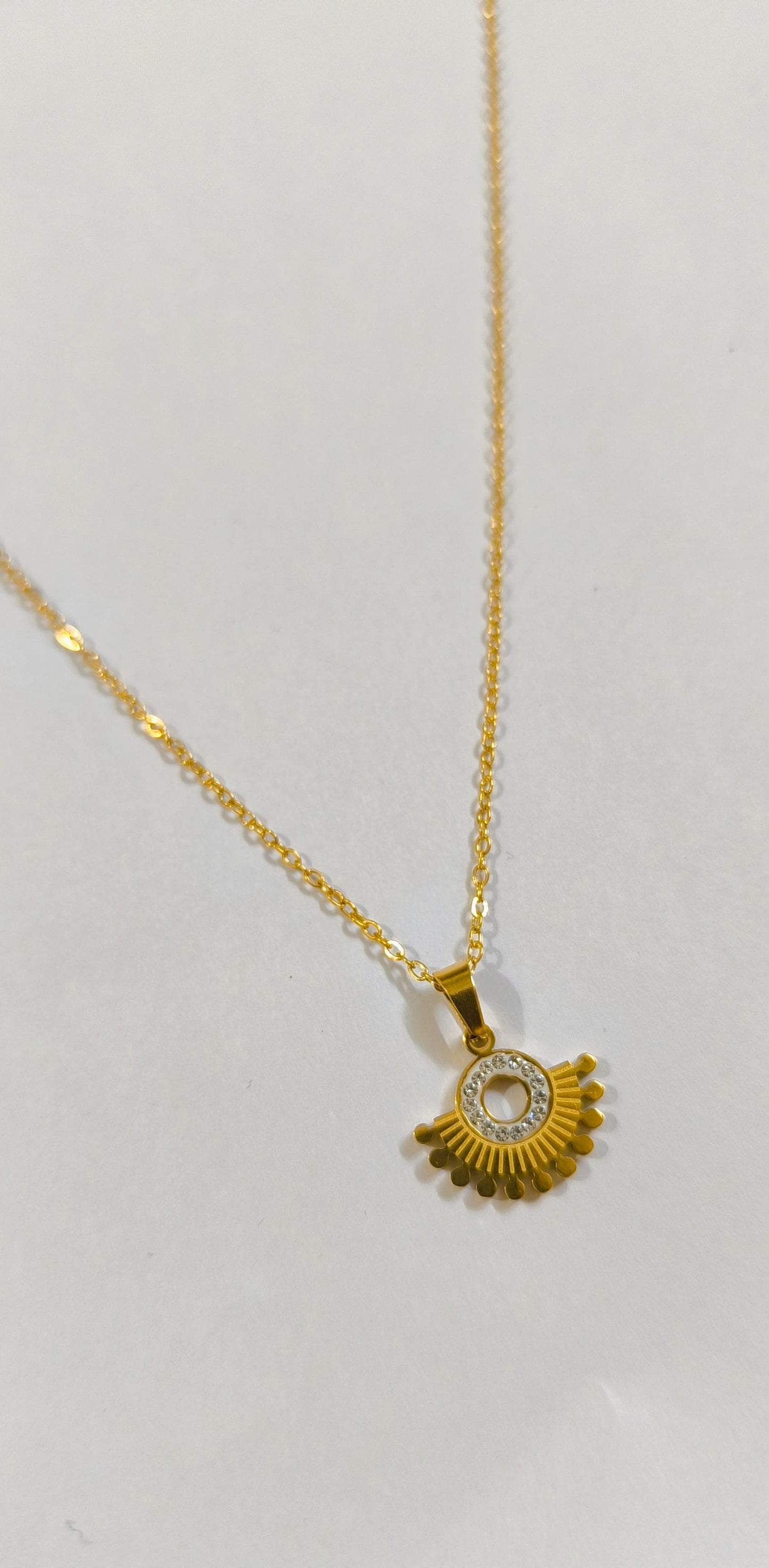 Dainty gold-plated necklace with circular pendant
Modern minimal pendant necklace in golden finish with stone work
Lightweight gold chain with a small designer round pendant
Saiyra’s elegant gold necklace perfect for casual and formal outfits
Unique handcrafted pendant with golden rays and crystal accents